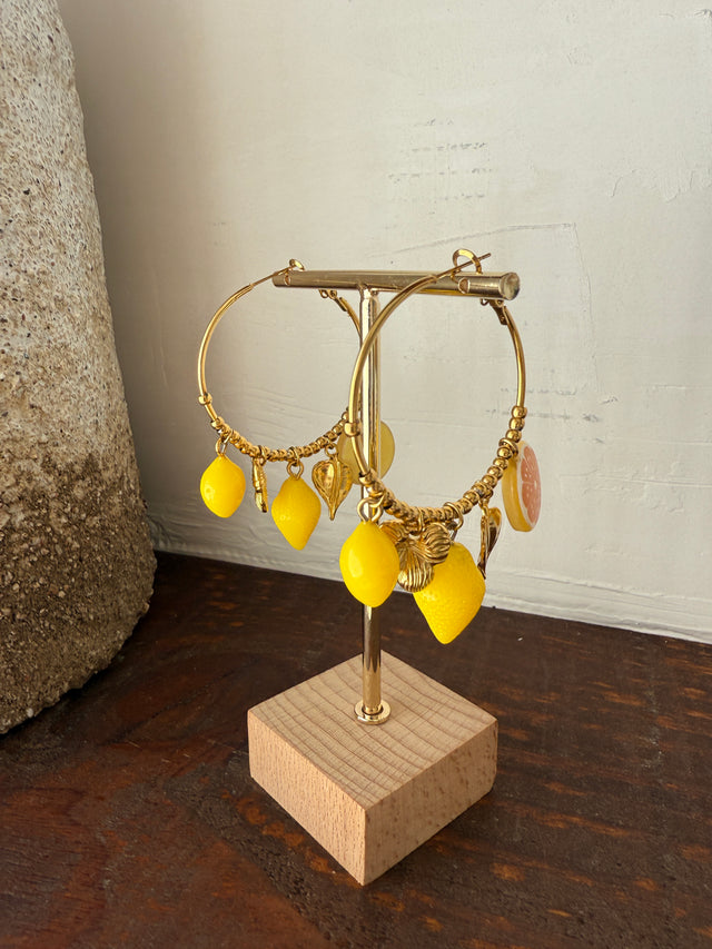 Argolas douradas com pendentes amarelos de limão e laranja, um toque divertido e vibrante para qualquer look.