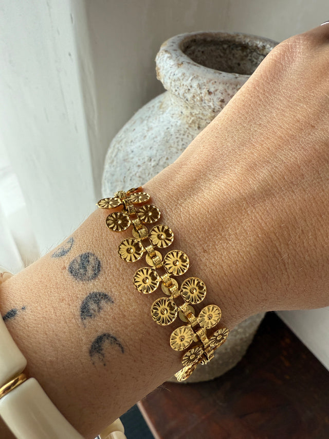 Pulseira dourada de aço inoxidável com design sofisticado, ideal para looks casuais e formais.