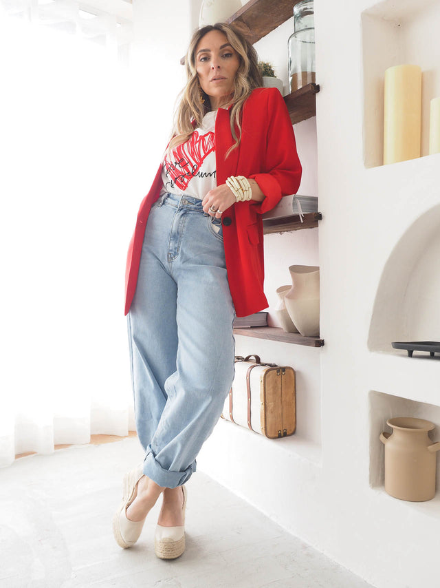 Woman in wide balloon jeans and a red blazer, showcasing a stylish modern outfit.