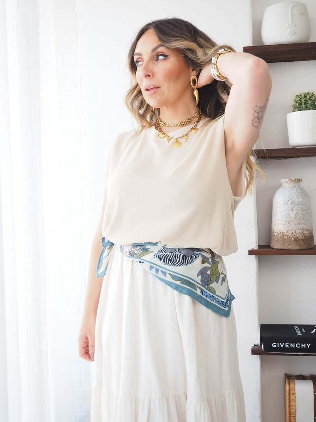 Camisola Malha Manga Cava em look minimalista com acessórios elegantes e cinto de lenço em padrão floral.