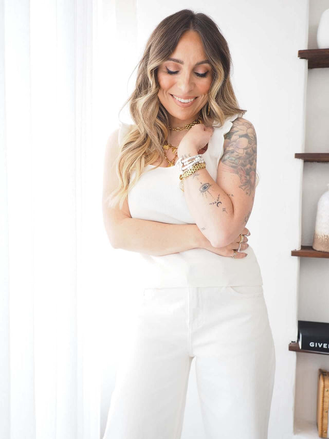 Modelo usando Top Malha Folho, mostrando elegância e conforto com decote quadrado e pormenor de folho.