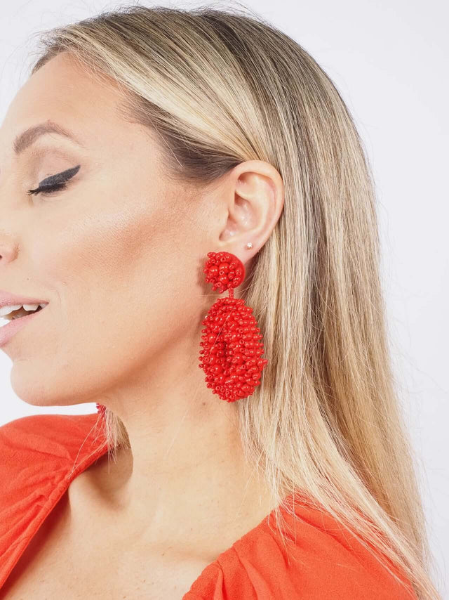 Brincos de fantasia, vermelhos com missangas.