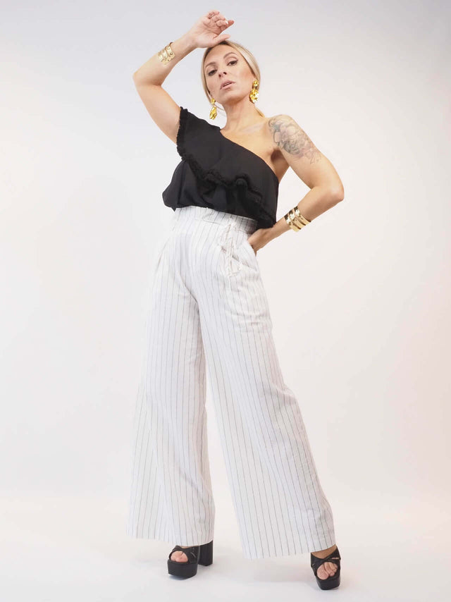 Conjunto de duas peças em tons monocromáticos, pantalonas largas de cós alto.
