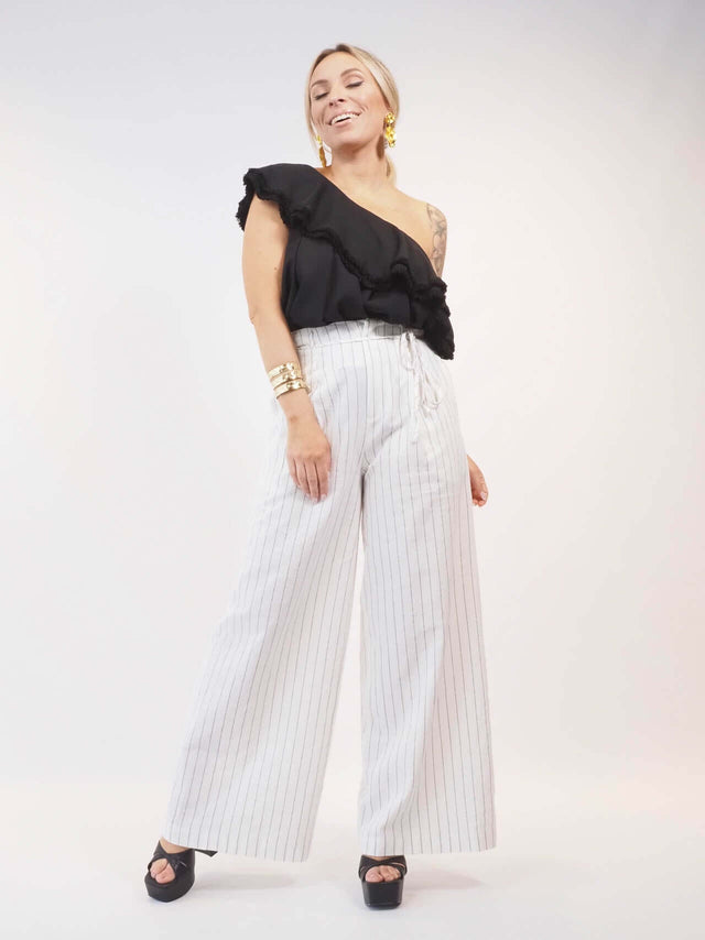 Conjunto de duas peças em tons monocromáticos, pantalonas largas de cós alto.