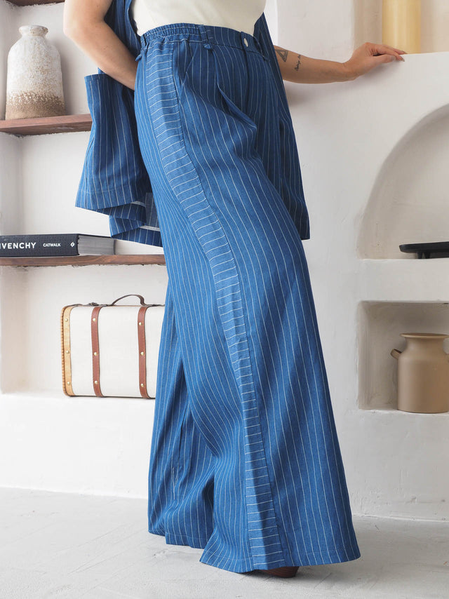 Calças pantalona às riscas em azul com cintura alta, estilo moderno e elegante, ideal para conforto e sofisticação.