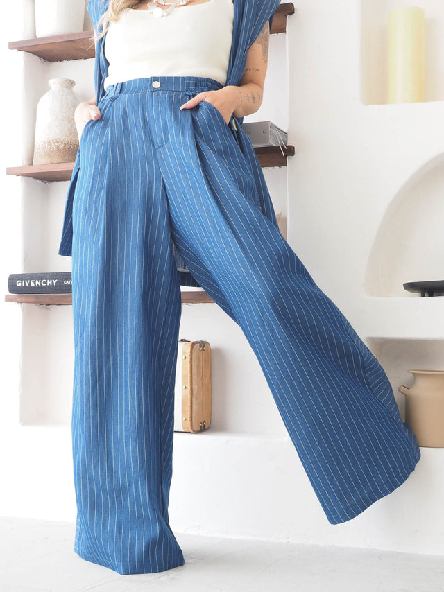 Calças pantalona às riscas azuis, elegantes e confortáveis, com cintura alta e fecho frontal, look moderno e sofisticado.