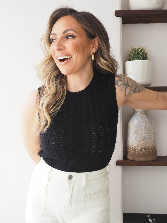 Top de malha preta elegante, com manga cava, ideal para looks casuais e frescos no verão.