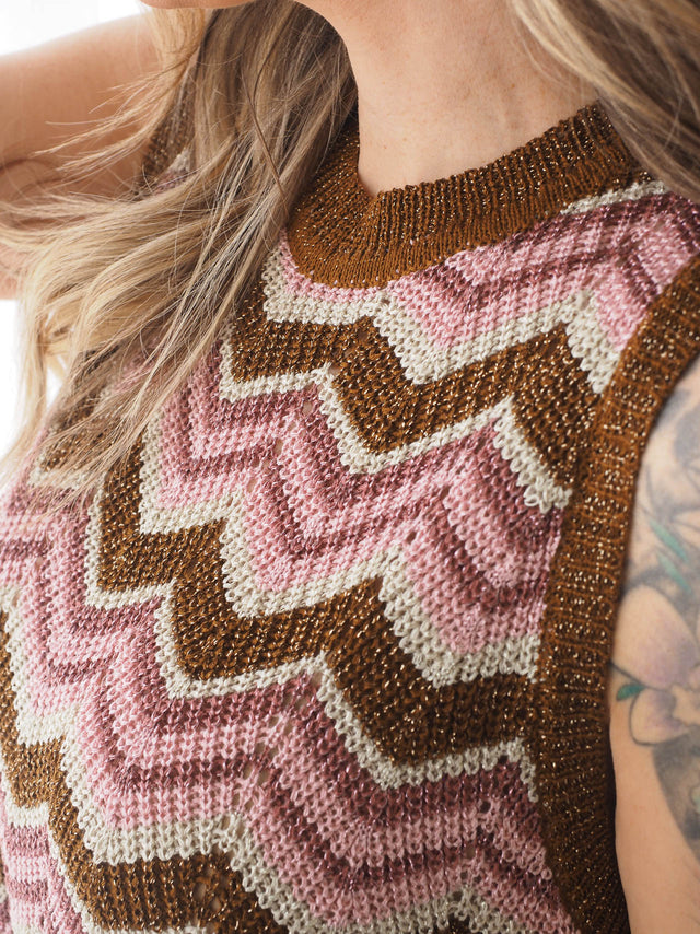 Top de malha com padrão zigzag em tons de rosa e castanho, ideal para looks elegantes e versáteis.