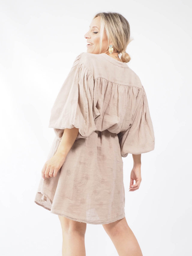 Vista de costas, o cinto aperta para dar uma cilhueta mais feminina e elegante ao conjunto.