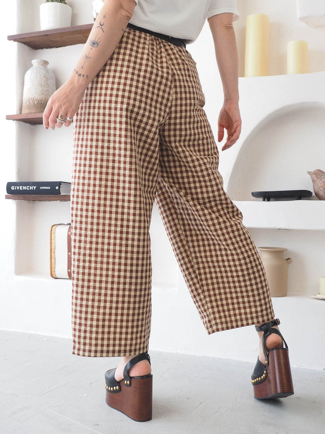 Calças xadrez largas em estilo moderno, com cintura alta e fecho de zipper, perfectas para um look casual e confortável.