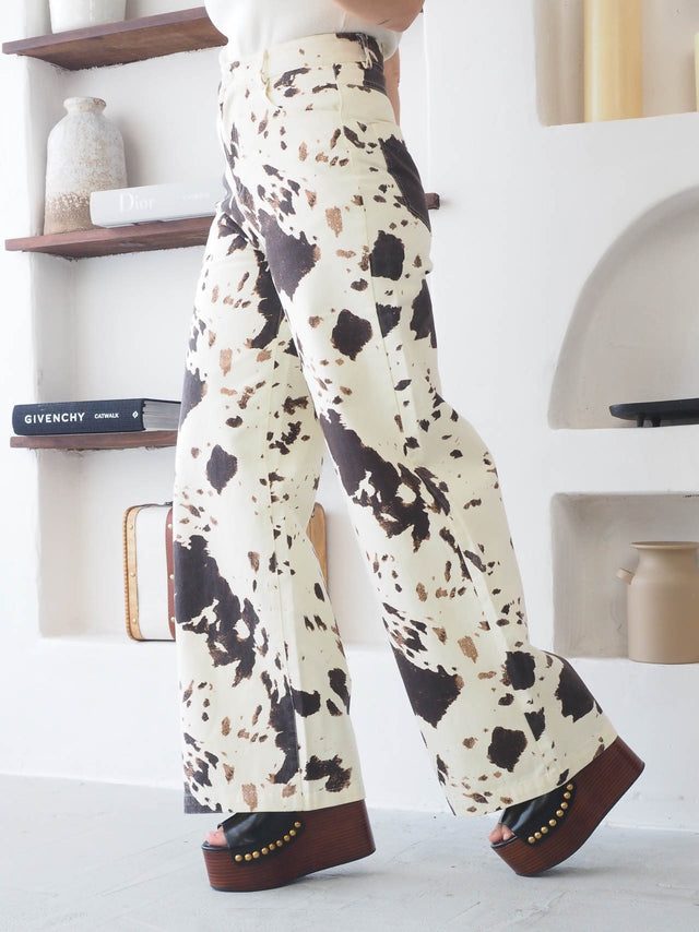 Calças de ganga estampado vaca em perna larga, ideais para um guarda-roupa de verão arrojado e divertido.