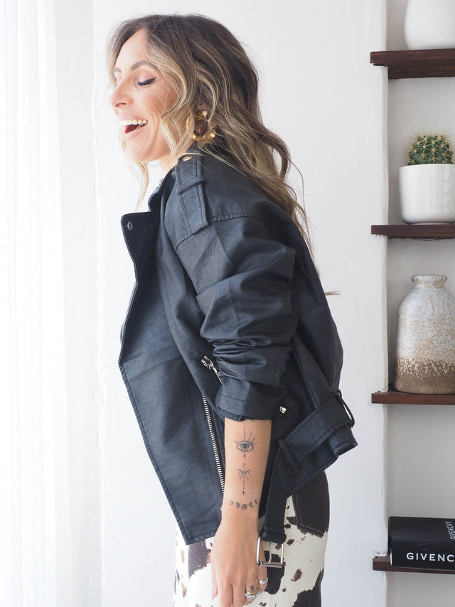 Blusão de ecopele preto com cinto, estilo moderno e urbano, perfeito para qualquer ocasião.