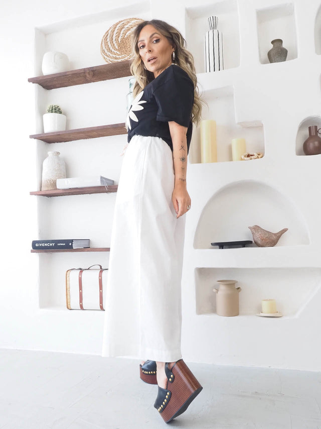 T-shirt flor bordada em look casual com saia branca e botas de plataforma elegantes.