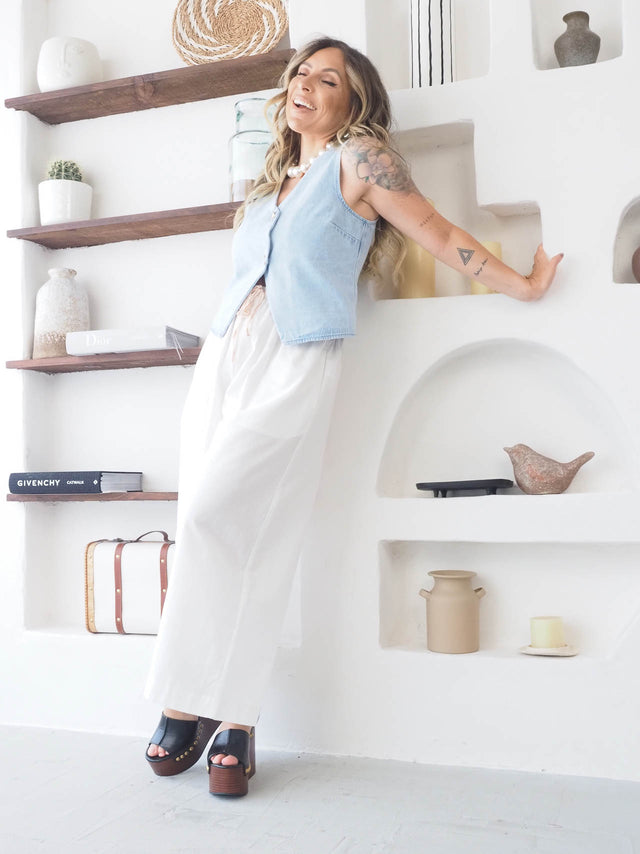 Mulher a mostrar colete de ganga cintado em ambiente moderno e luminoso, ideal para looks casuais e estilo urbano.