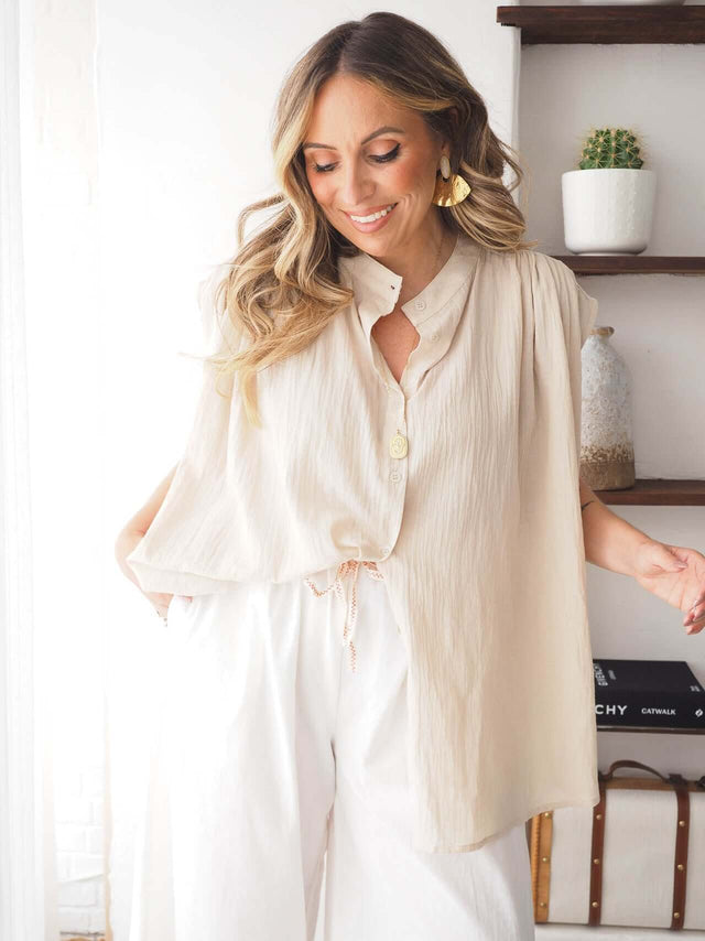Camisa Manga Cava oversized em malha canelada bege com fecho de botões e gola redonda, ideal para um estilo moderno e confortável.