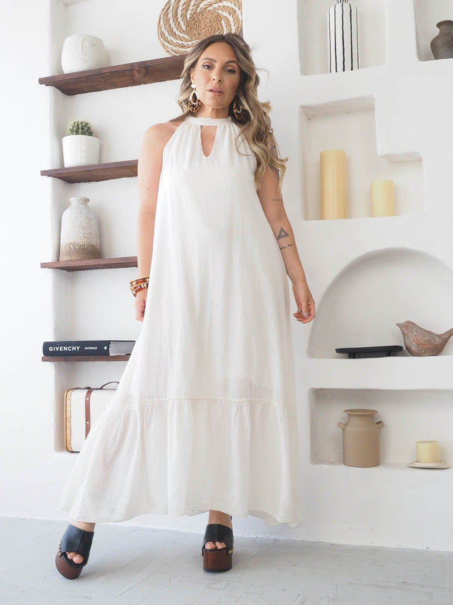 Modelo vestindo um vestido comprido de algodão halter, perfeito para o verão, com design elegante e moderno.