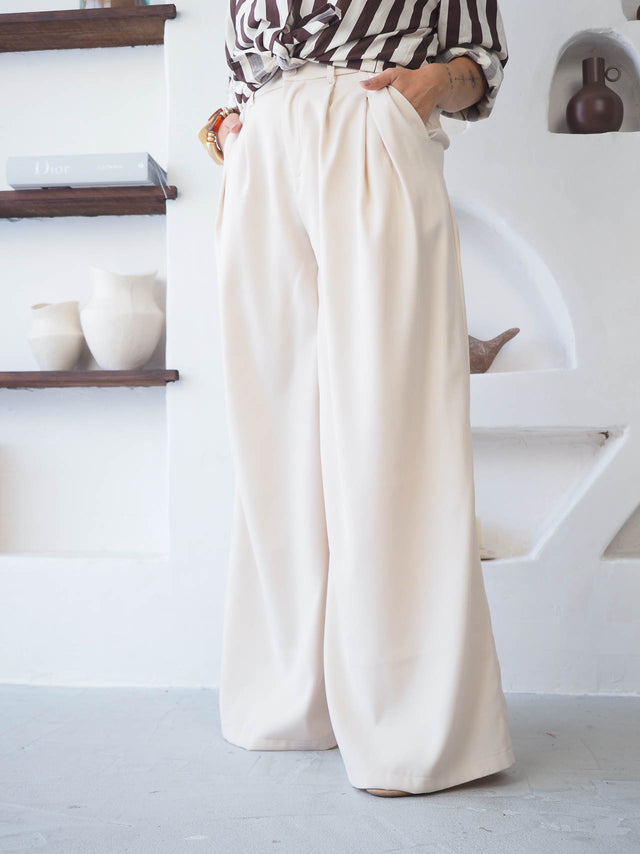 Calças com pregas de cintura alta, elegantes e confortáveis, com bolsos frontais discretos e caimento fluido.