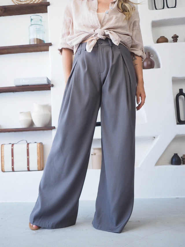 Calças com pregas frontais, cintura alta e tecido fluido, perfeitas para um look elegante e moderno.