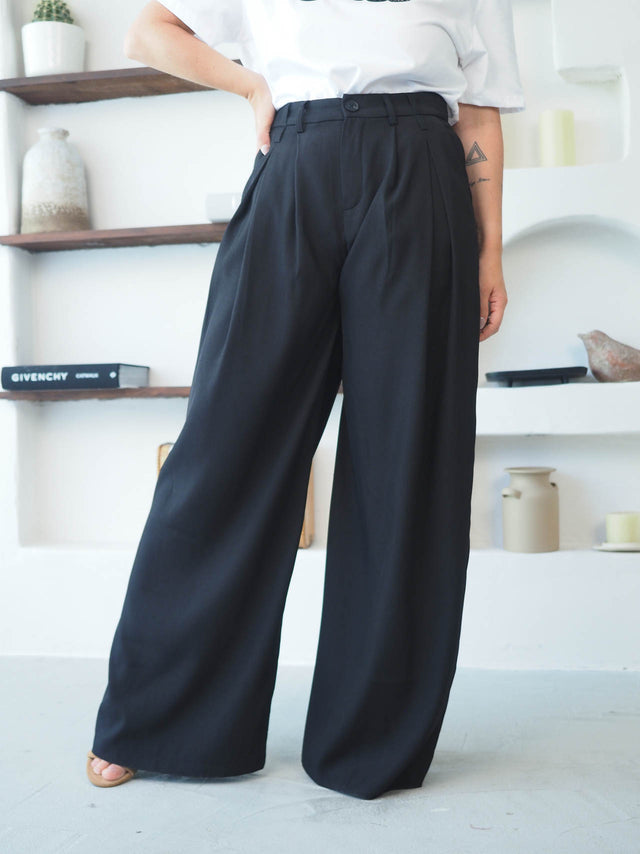 Calças com pregas frontais em preto, alta cintura, para um look elegante e moderno, com caimento fluido.