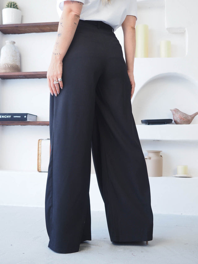 Calças com pregas pretas, cintura alta, elegância e conforto moderno, ideal para um look sofisticado.