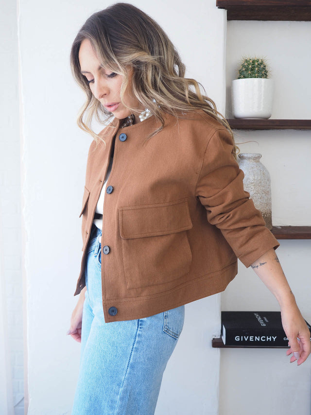 Blusão curto com botões, elegância discreta e cortes estruturados, ideal para looks formais ou casual-chic.