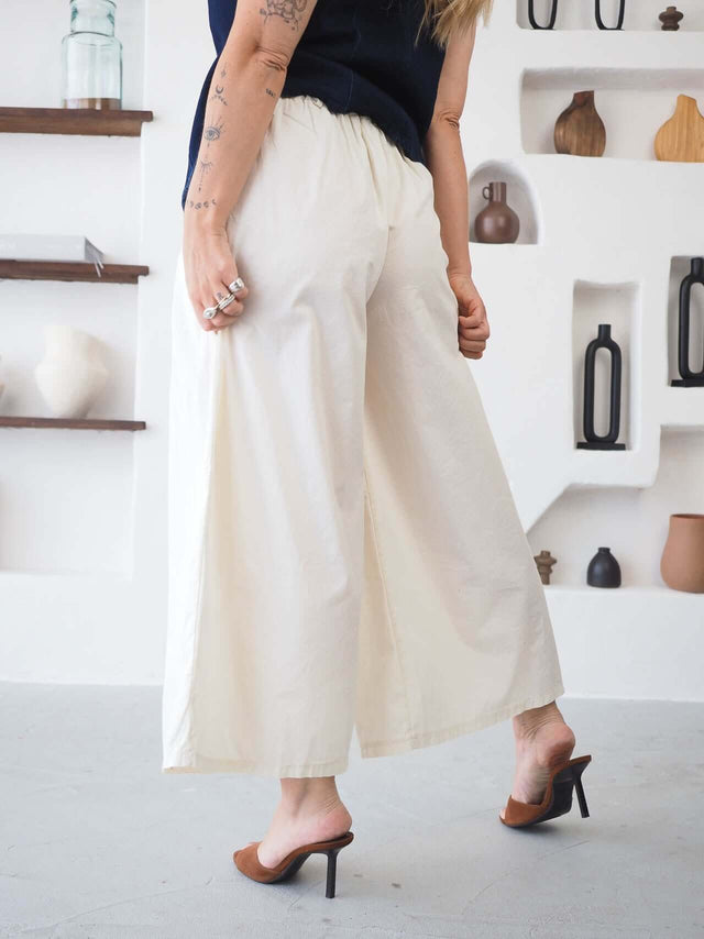 Calças Culote em algodão, bege, de perna larga e cintura elástica, ideal para um look confortável e elegante.