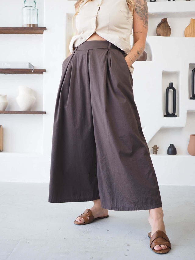 Calças Culote castanho de cintura elástica e perna larga, com pregas frontais para um look elegante e confortável.