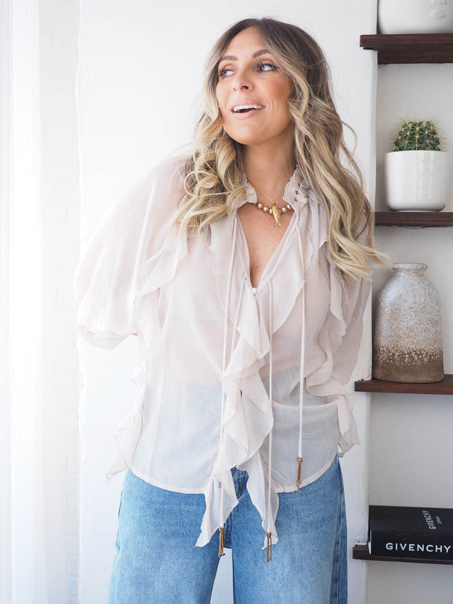 Blusa com folhos em tecido fluído, ideal para looks femininos elegantes e confortáveis, combinada com jeans largos.
