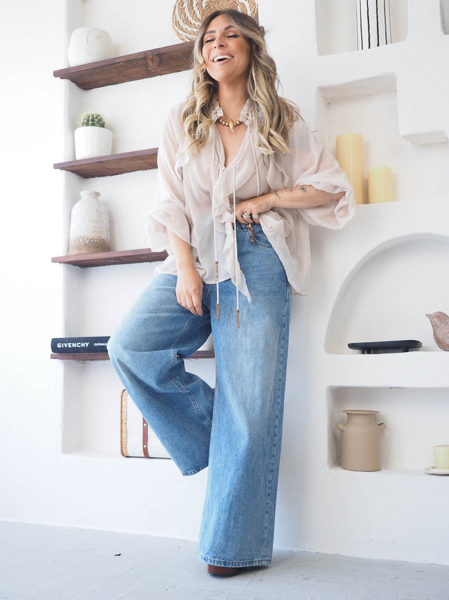 Blusa com folhos em tecido fluído, combinada com jeans wide leg, perfeita para looks femininos elegantes e confortáveis.