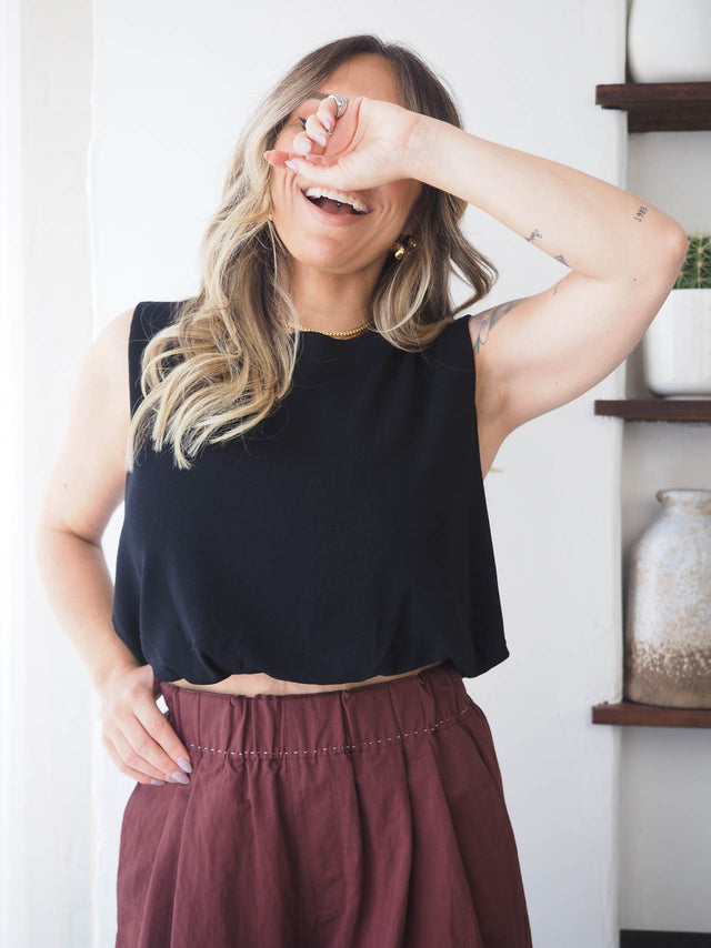 Top de malha fresca preta, gola redonda e manga cava, ideal para looks de primavera/verão.