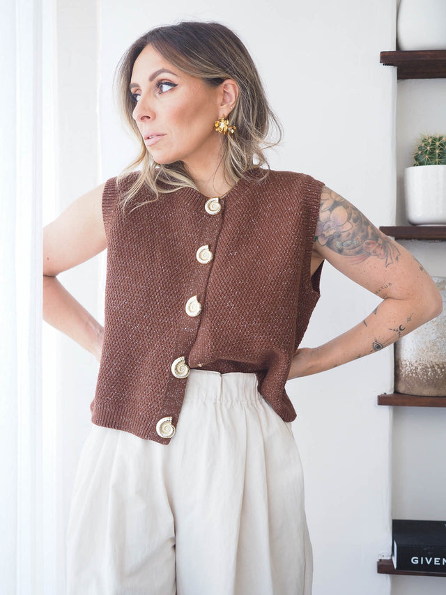 Colete de malha feminino elegante em tons de castanho, usado com calças largas, ideal para looks de primavera verão.