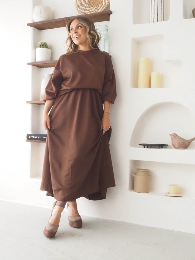 Modelo feminina em vestido longo marrom, confortável e elegante, perfeito para a primavera e verão.