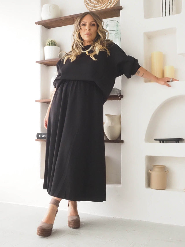 Conjunto de felpa feminino com sweatshirt e saia longa preta, ideal para looks confortáveis e modernos.