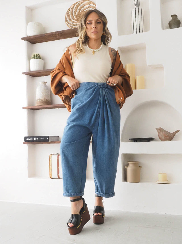 Calças baggy balloon com cintura alta, combinadas com blusa básica e casaco oversize, ideal para look primaveril.