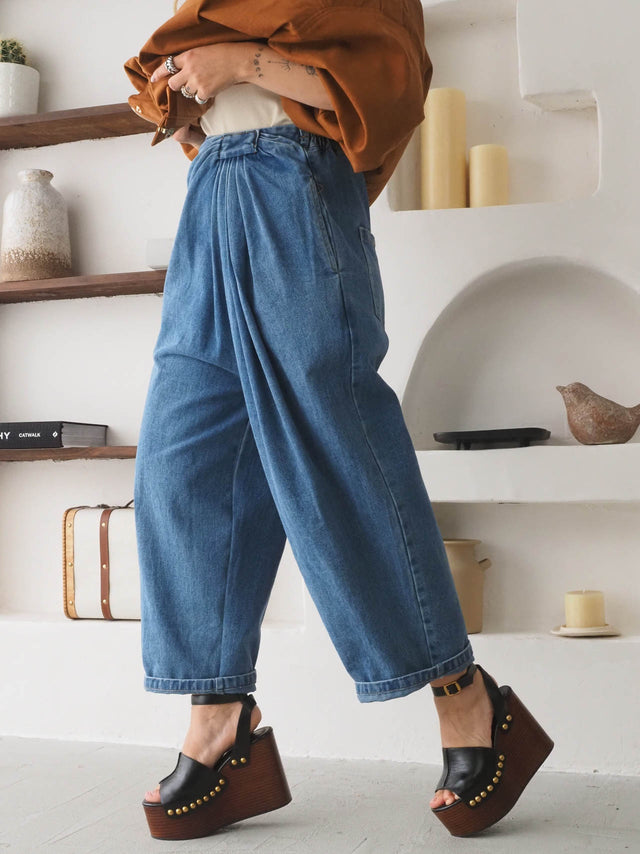 Calças baggy balloon cintura alta em denim, com detalhe de drapeado, perfectas para um visual moderno e descontraído.