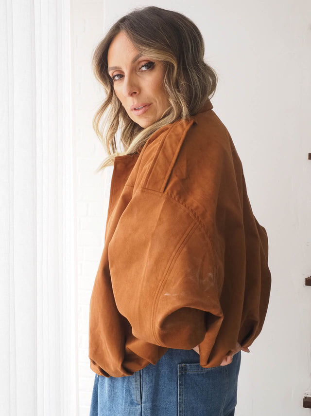 Blusão efeito camurça oversized feminino em tom terracota, ideal para looks primavera verão, combinado com jeans largo.