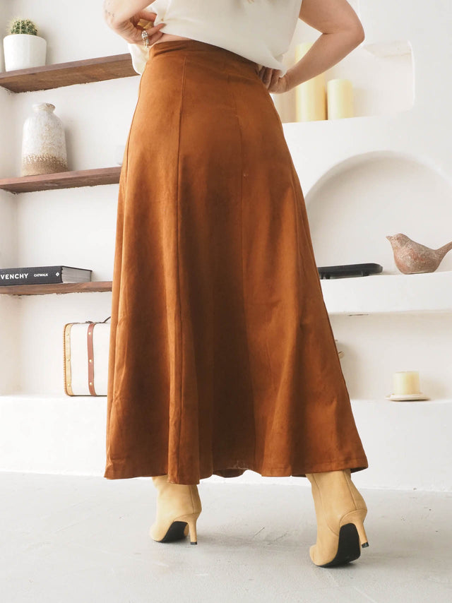 Saia midi efeito camurça em tom castanho, com corte fluido e elegante, ideal para looks casuais ou formais.