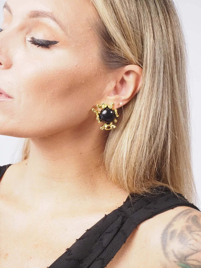 Brincos de senhora com pedra preta e dourados.