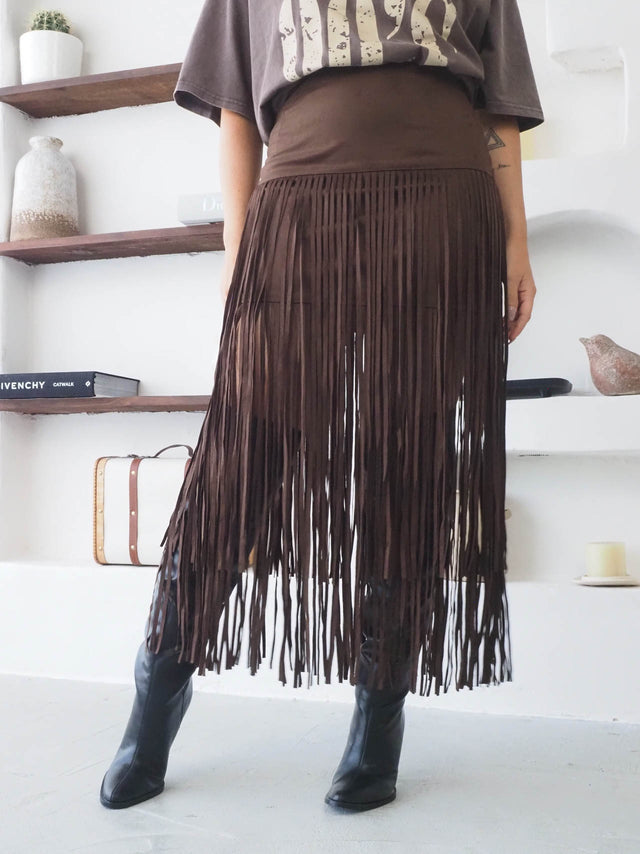 Saia com franjas eficaz, em camurça castanho, ideal para looks boho-chic e estilosos, combinada com roupa casual feminina.