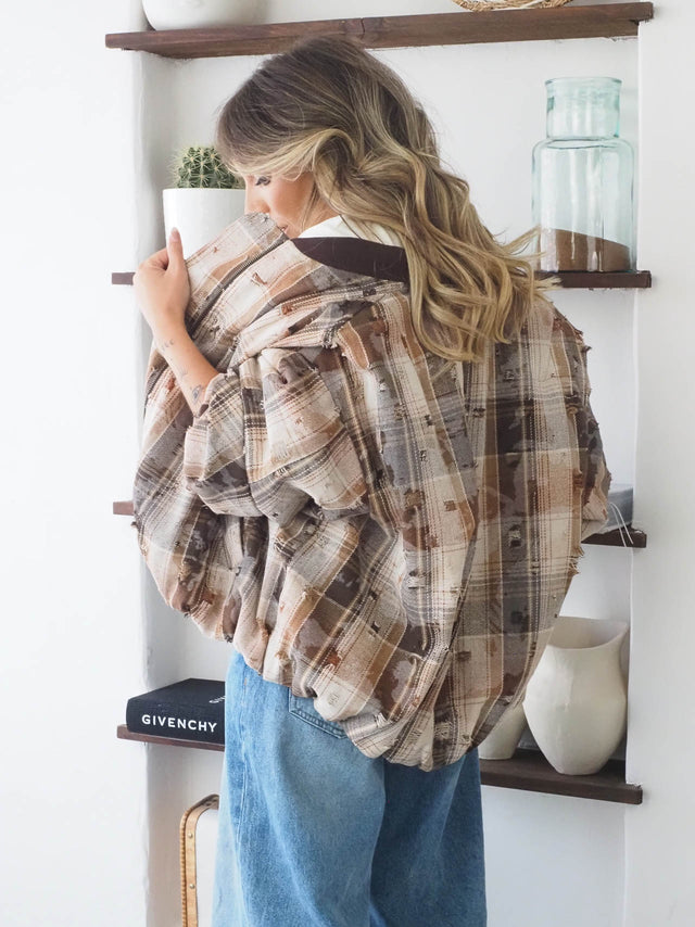 Blusão xadrez oversized com rasgões, ideal para looks casuais e descontraídos, combinado com calças de ganga.