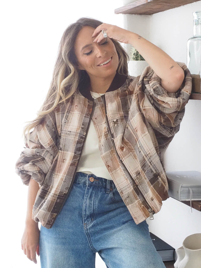 Blusão xadrez feminino com rasgões, ideal para looks casuais e modernos, combinado com calça de ganga. Moda primavera-verão.