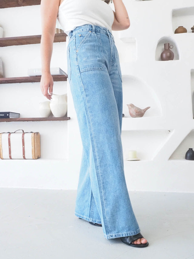 Jeans wide leg de cintura alta em denim azul, com bolsos funcionais, ideal para looks modernos e confortáveis.