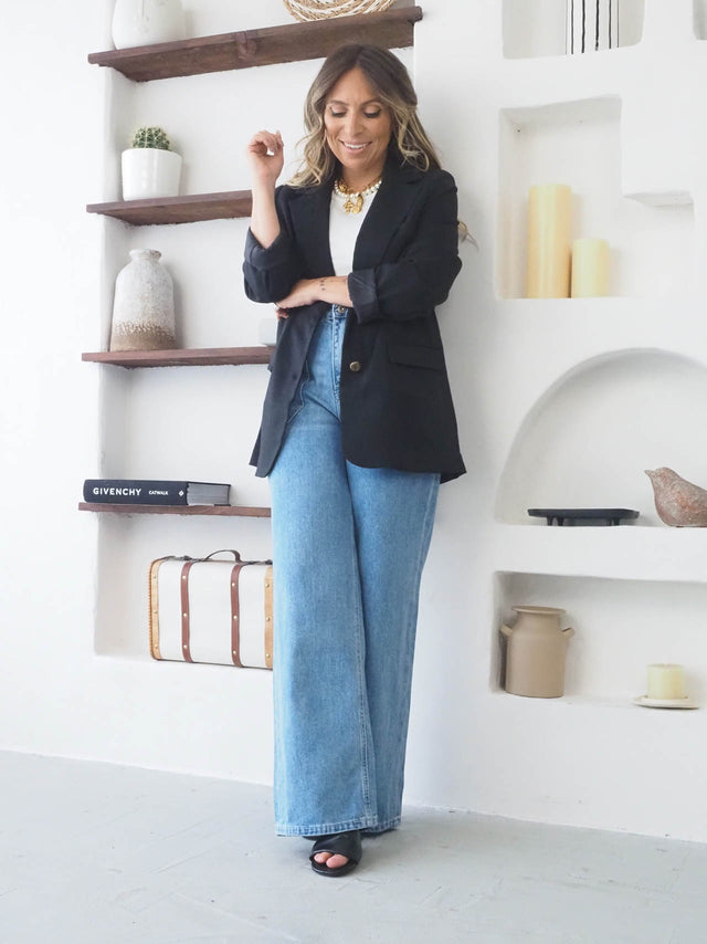 Modelo vestindo blazer feminino elegante com calça wide leg em ambiente moderno, ideal para primavera verão.