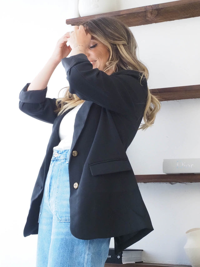 Blazer feminino corte reto em preto, combinado com calça jeans de cintura alta e blusa básica, ideal para um look elegante.