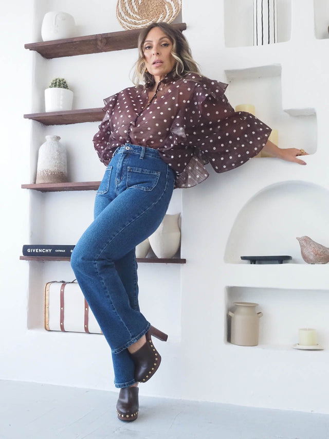 Mulher usando Calças de Ganga Regular Bootcut em ambiente moderno com blusa de bolinhas.