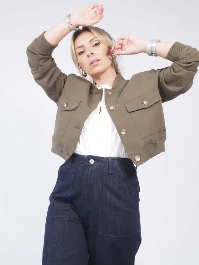 O blusão curto possui uma gola redonda que adiciona elegância ao look