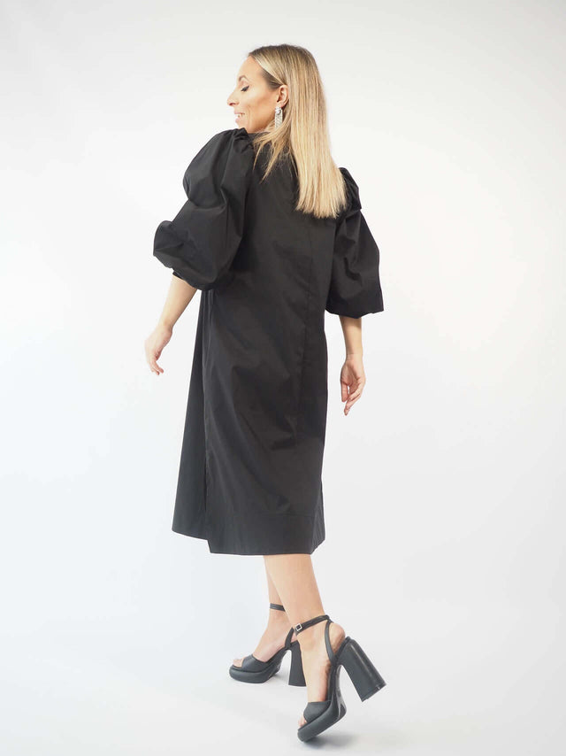 Vestido com detalhes franzidos no ombro, fecho de botão atrás.