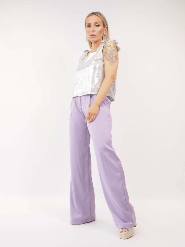 Calças pantalonas em cetim, combinado com top em lantejoulas prateado para um look de festa perfeito.