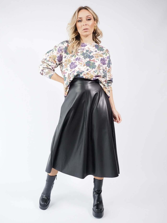 Conjunto de saia em ecopele com uma camisola de malha.