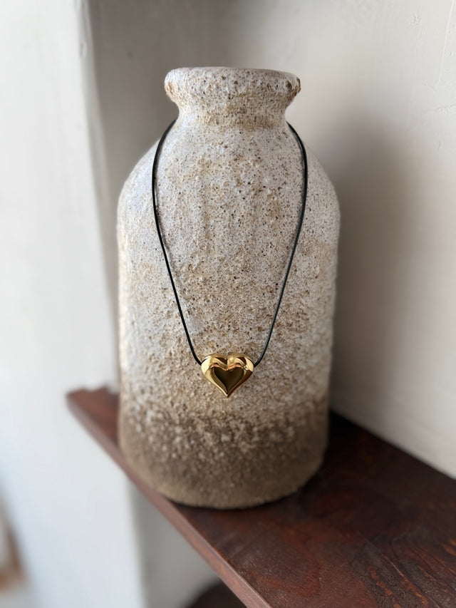 Colar ajustável em corda preta com coração dourado, estiloso e contemporâneo, ideal para qualquer ocasião.